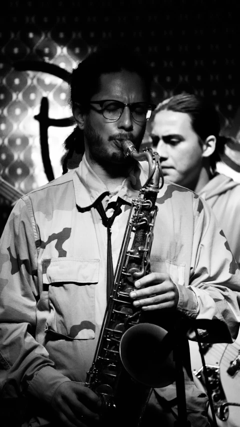 a man playing the saxophone with a friend