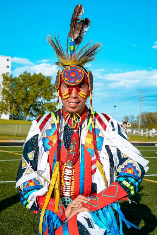 a man with colorful attire and feathers on his head