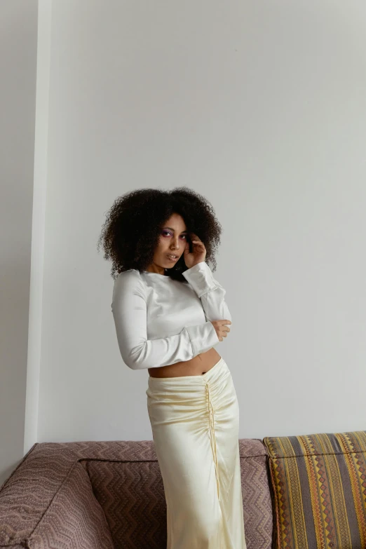 a black woman with curly hair standing on a couch