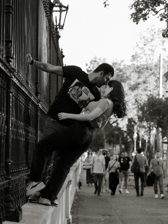 a man and woman kissing on the sidewalk