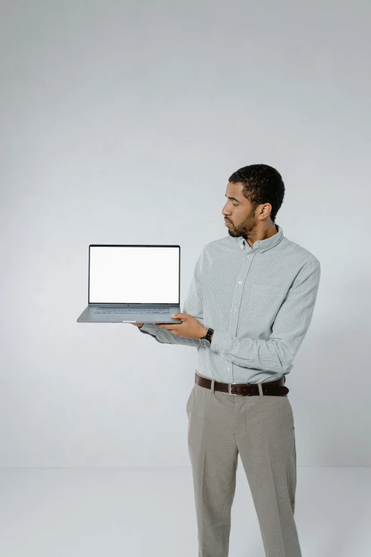 a man standing with a laptop in his hand