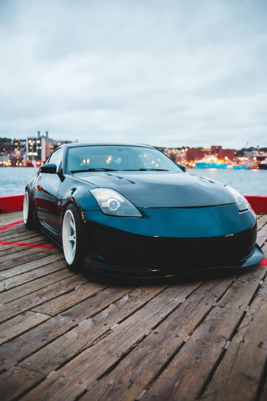 a black sports car parked on the side of the water