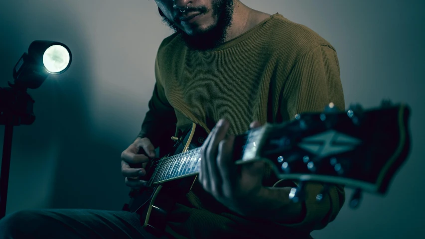 a man that is sitting down with a guitar