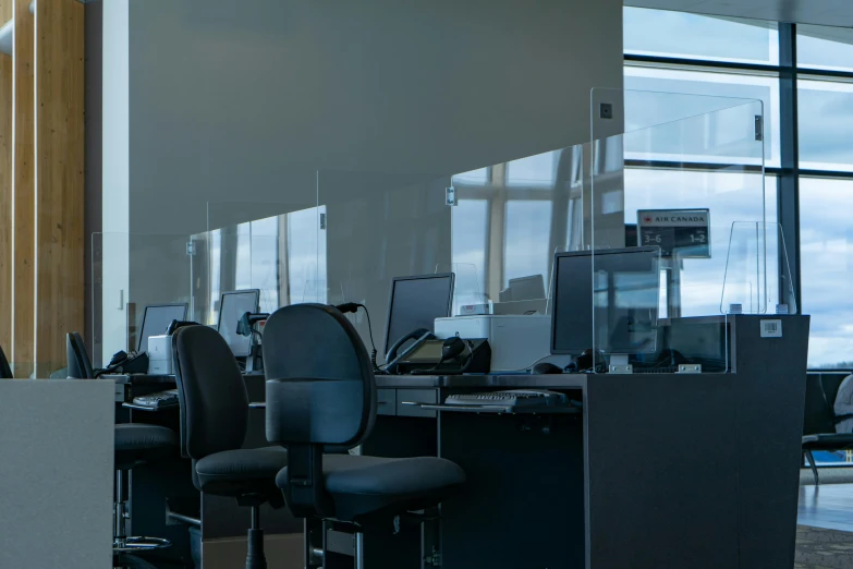 an office area with computers, keyboards, and chairs