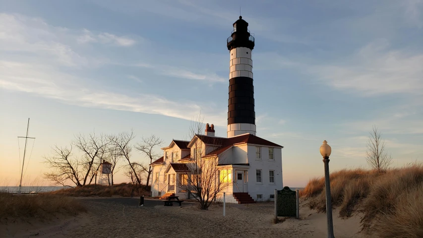 there is a lighthouse in front of some sandy areas