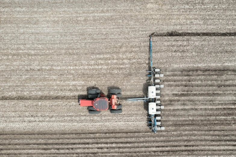 the tractor is pulling two small carts in the field