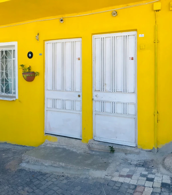 a yellow house is shown with two windows