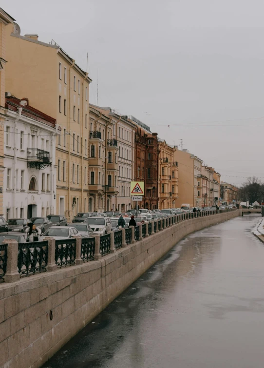 a waterway and cars on the side of it near many buildings