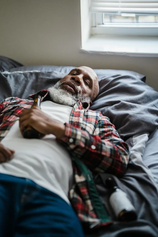 a bearded man in a plaid shirt with his hand on the belly of a pillow