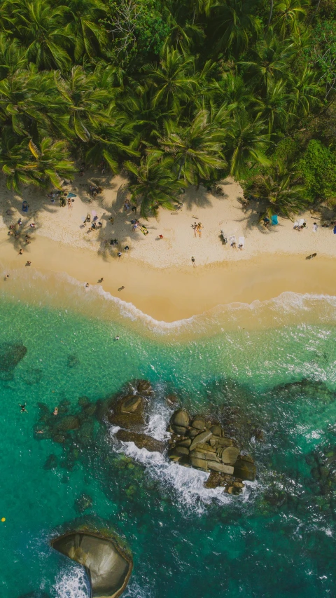 a view of a sandy beach with clear blue water and people on the shore