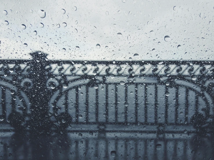 a gate is seen through the rain - soaked window