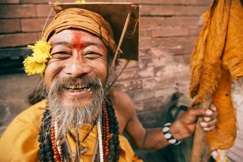 a smiling man with a large white and yellow head piece