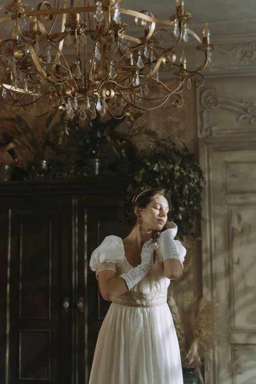 a beautiful woman in a wedding dress and a chandelier