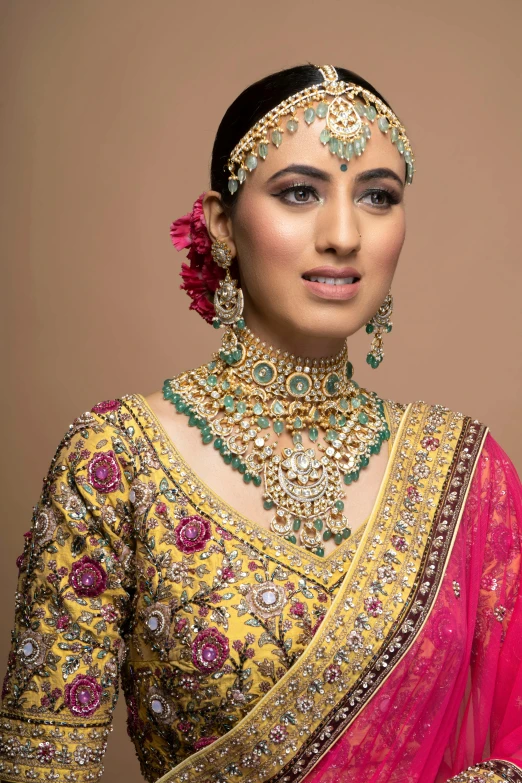 an indian woman in a gold and red bridal gown