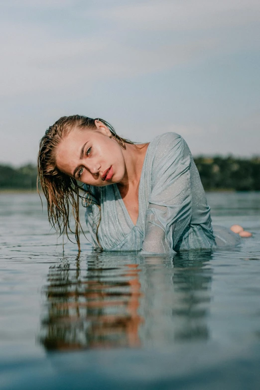 a girl is floating on her head in the water