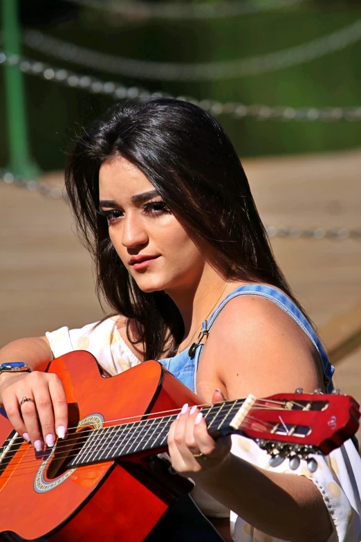 a beautiful young woman holding a red guitar