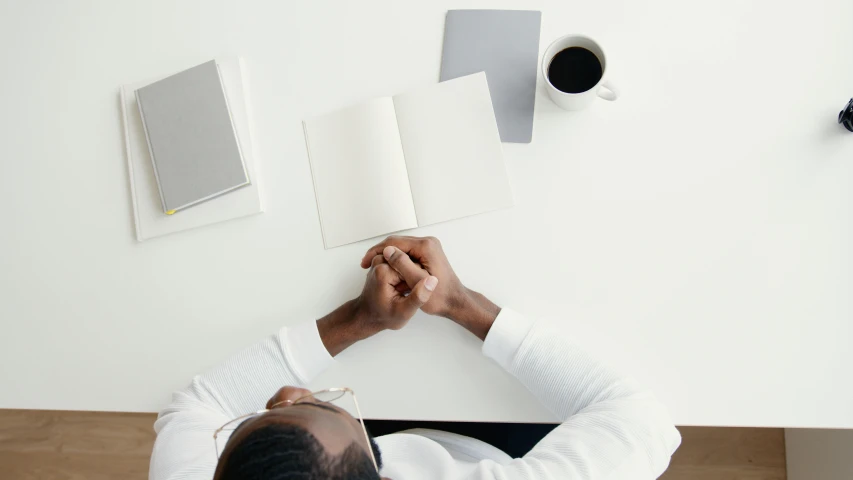 man writing on top of a white piece of paper