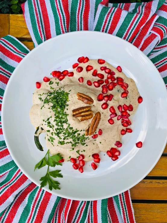 the hummus has been garnished with pecans and green leaves