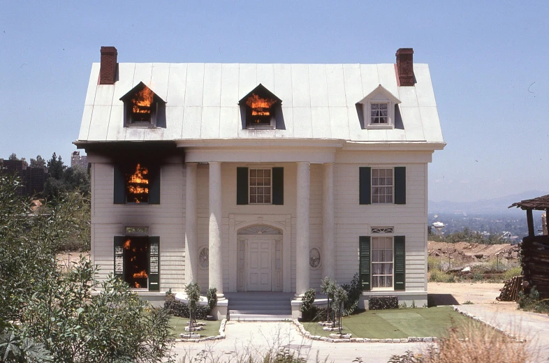 a white house that is near a small building