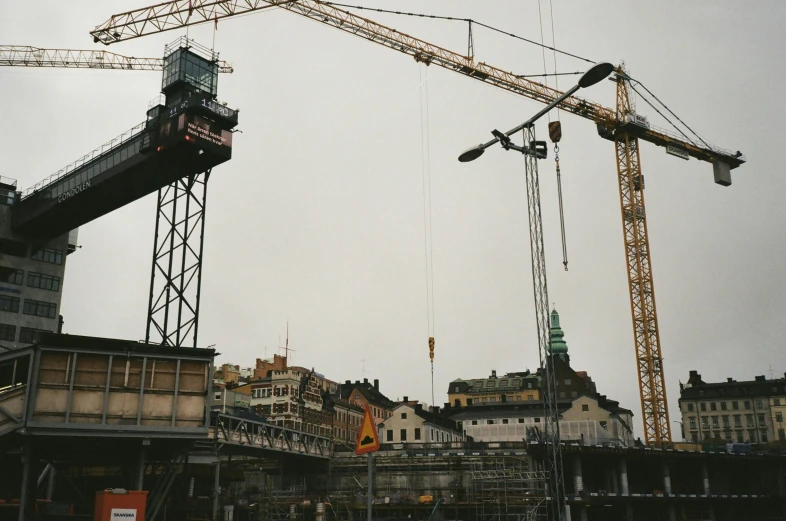 some construction cranes are sitting in the city