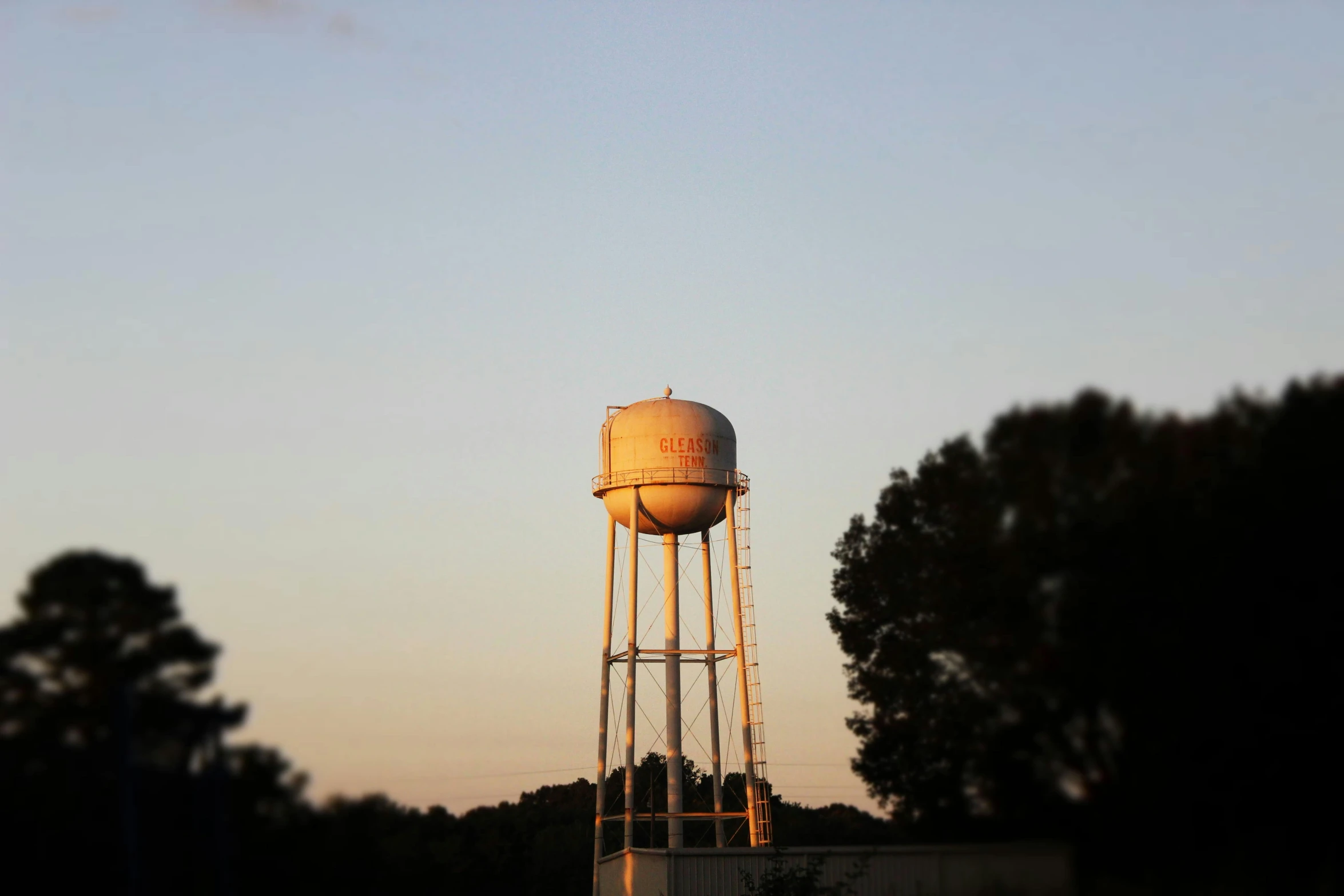 a white water tower is shown on a cloudy day