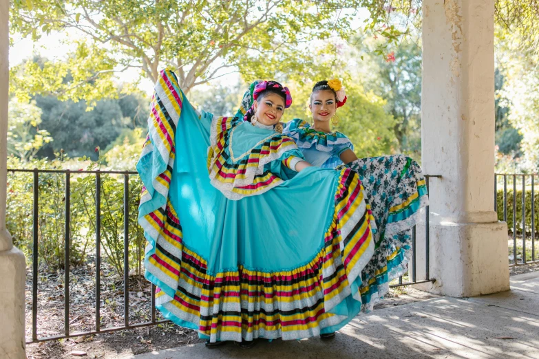 two people dressed in colorful clothes posing for the camera