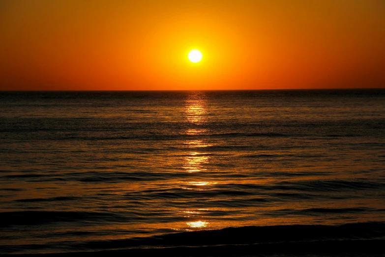 the sun is setting over the ocean in the sunset