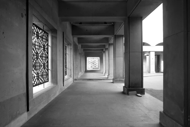 black and white pograph of long hallway with lots of windows