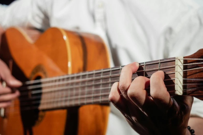 a person holding a guitar while standing next to another man