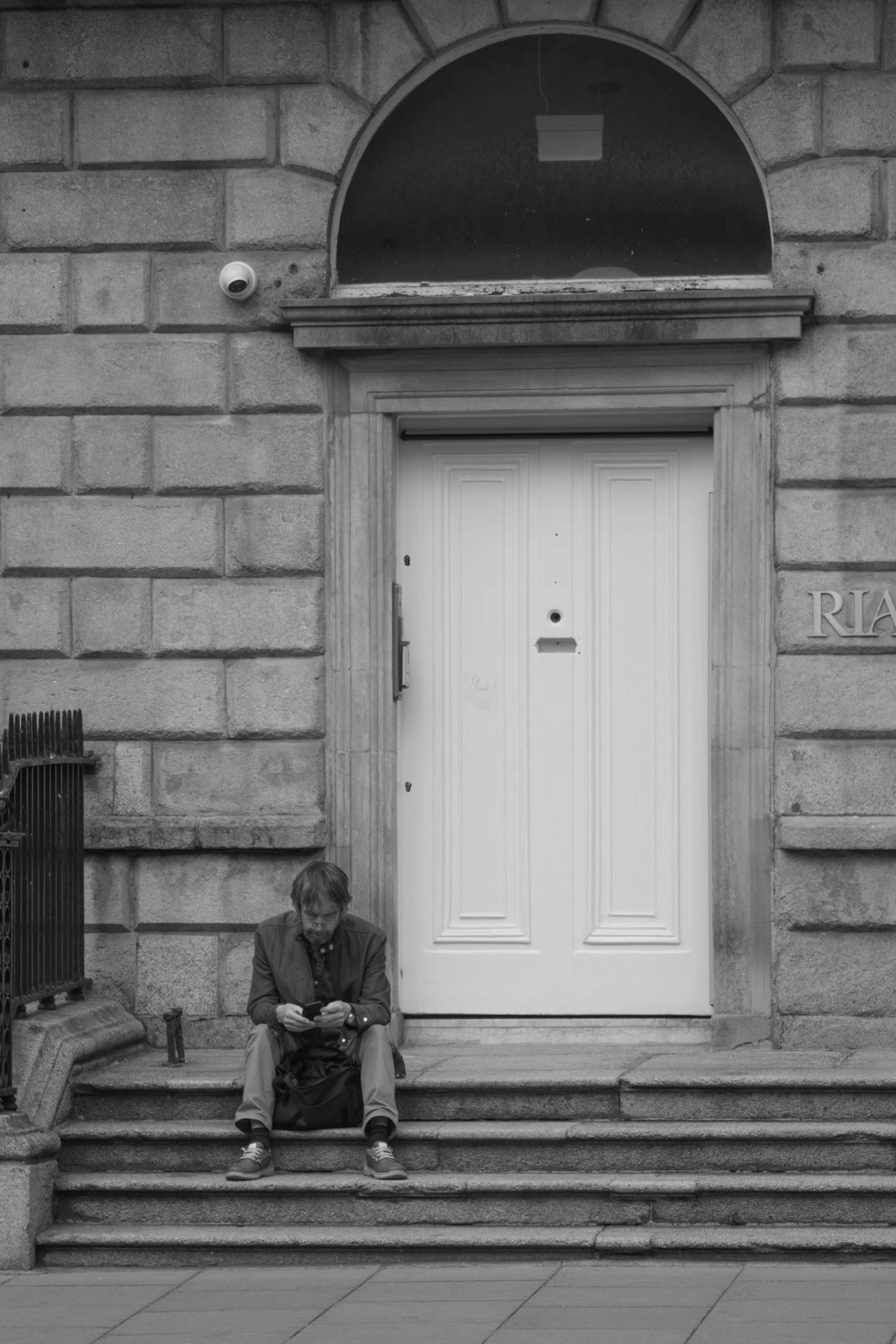 man sitting on the steps of a building reading soing