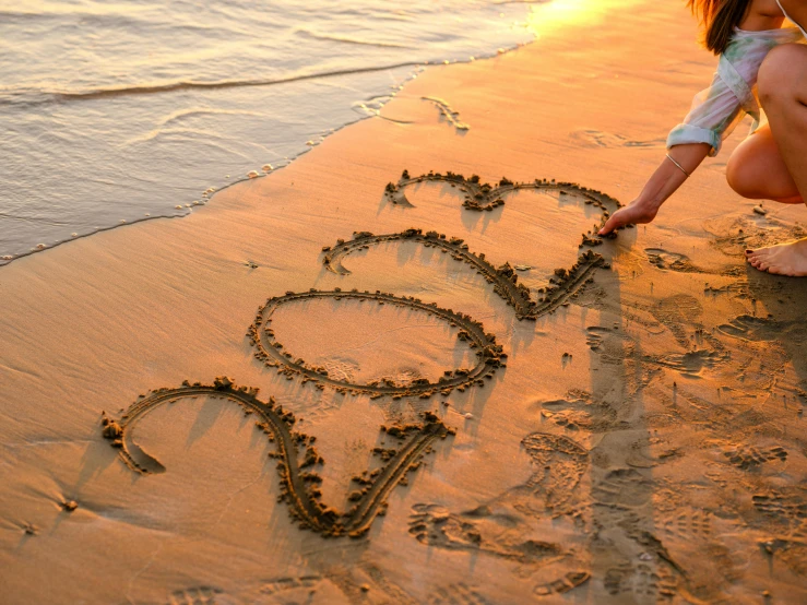 a couple writing in the sand on the beach