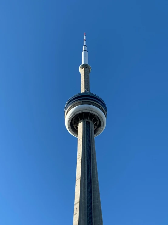 a tall tower with a clock is in the middle of a blue sky