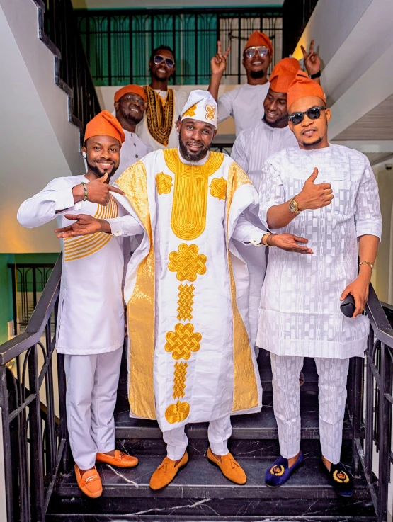 group of people wearing matching outfits standing on stairs