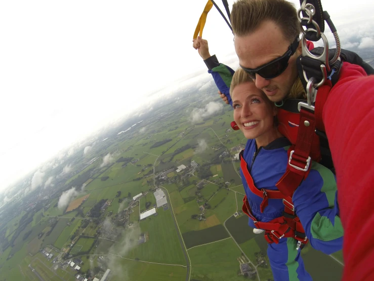 a man and woman standing in the sky while parasailing