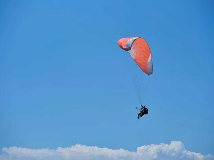 there is a person in the sky holding on to a parasail