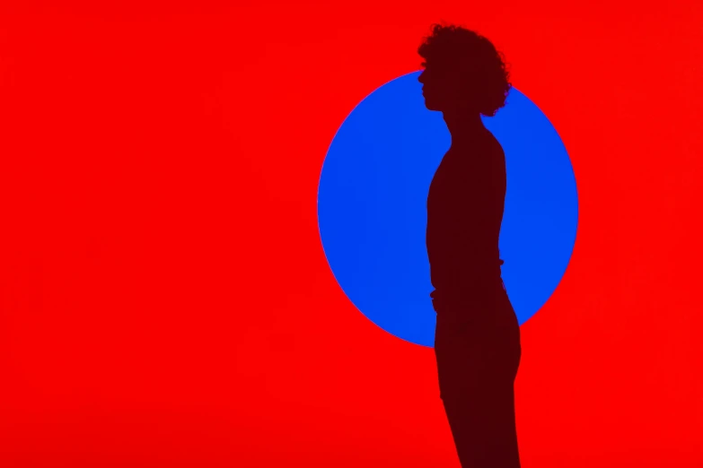 an abstract silhouette of a woman in black on a red and blue background
