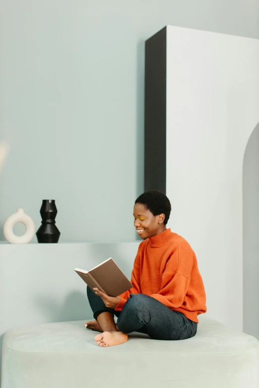 a woman sits on a bench while reading a book