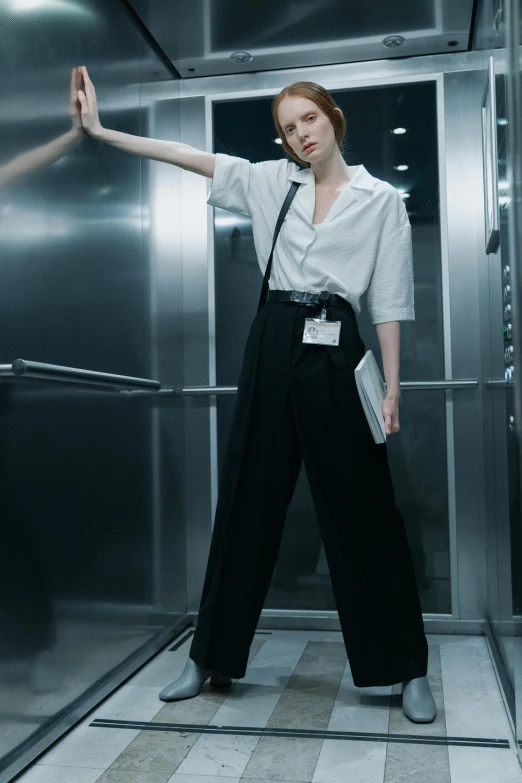 woman standing in open elevator area with hand on door