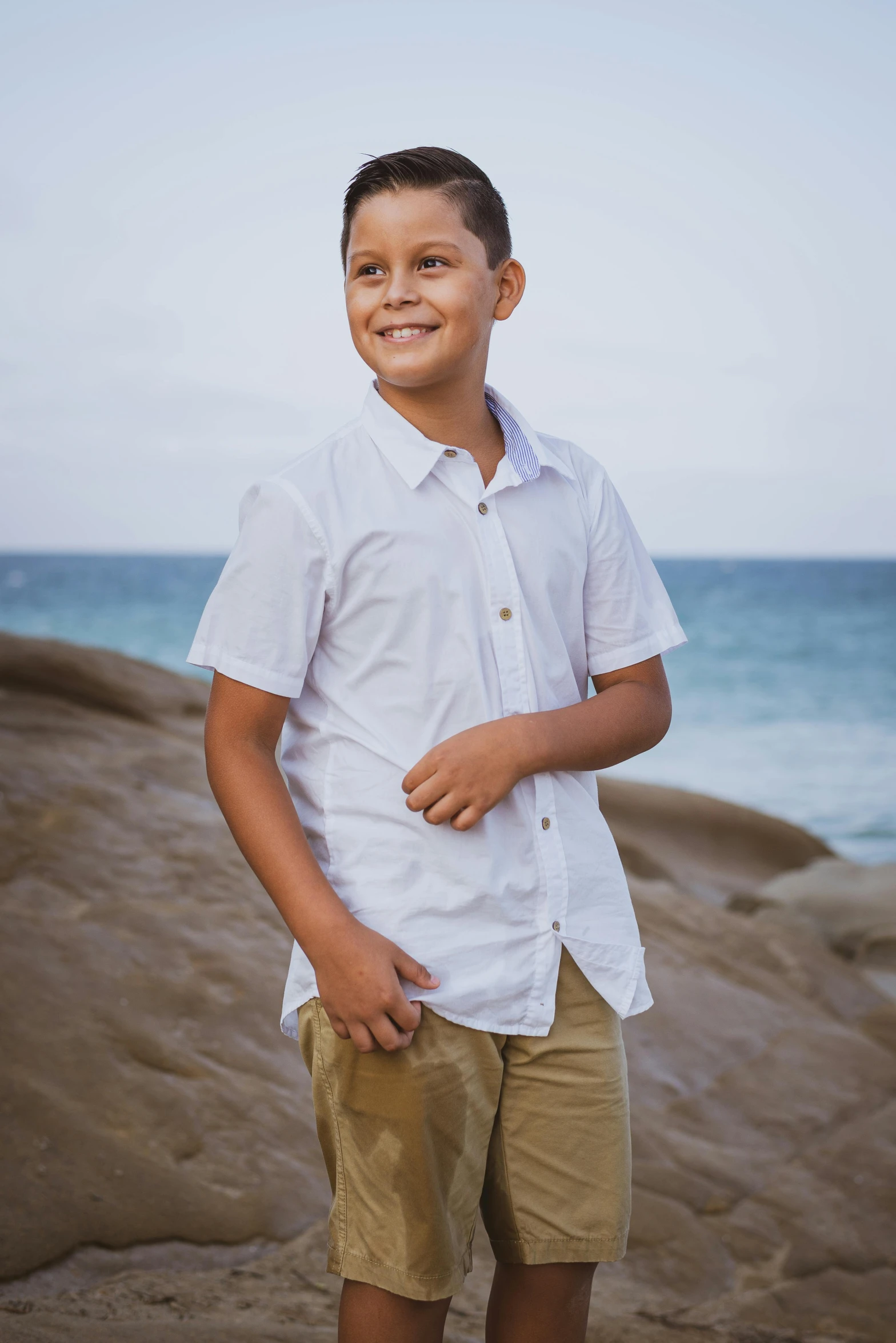 a young man standing on top of a sandy beach