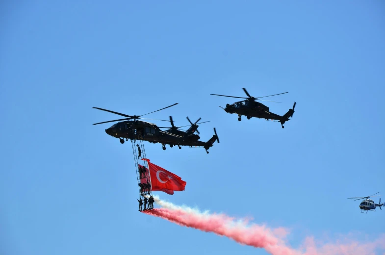 a formation of four helicopter dropping red flags