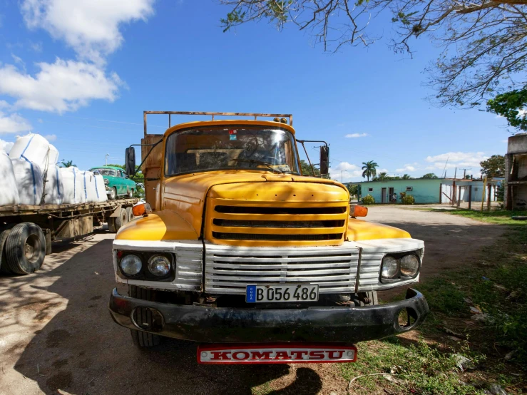 there is a yellow truck and some trees