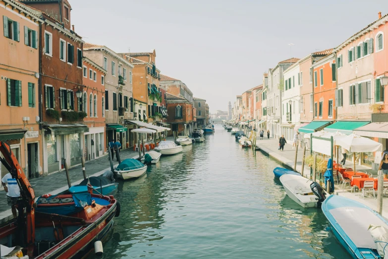 people and motor boats on the waterway in venice, italy