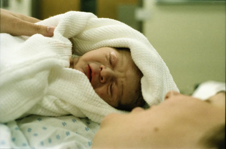 a person with a blanket on a bed