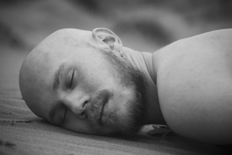 a man with a beard sleeping on the floor