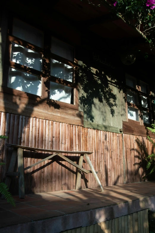 a wooden bench sitting next to a wooden wall