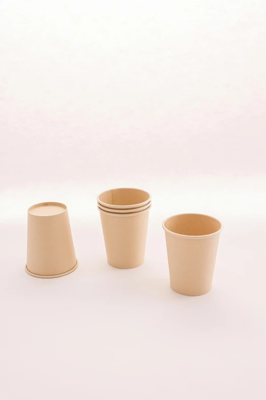 three cups sitting next to each other, one empty, one with no top on