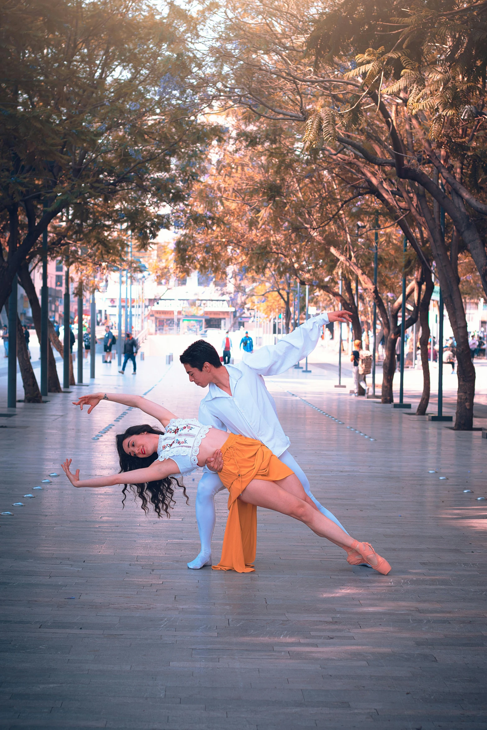 a man and woman dancing in a city plaza