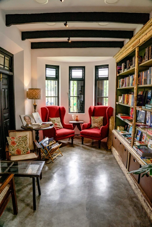 a small room with several red chairs and bookshelves