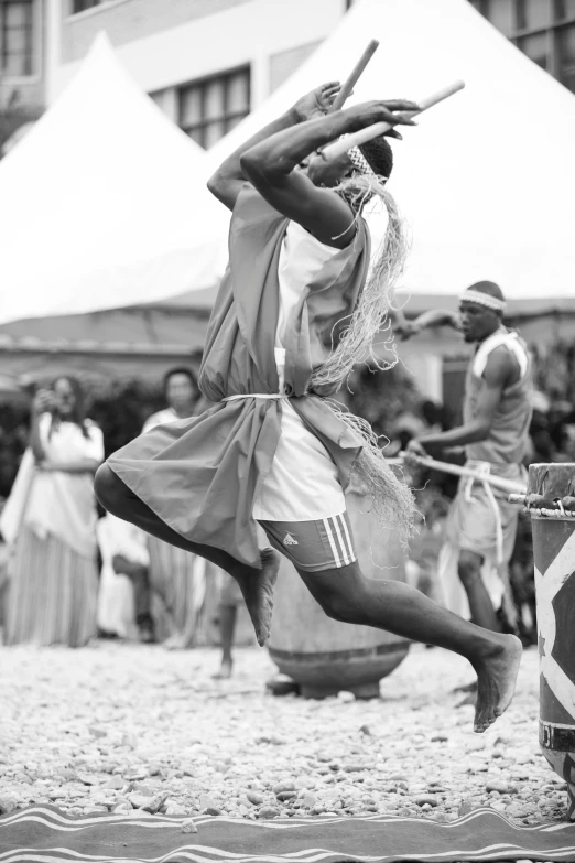 a man in costume and holding stick is on the ground