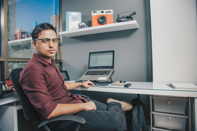 a man with a laptop sitting at a desk